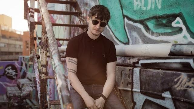 Picture of Ryan McMullan sitting on a rooftop