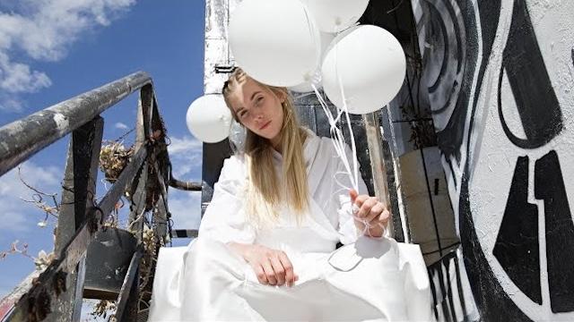 Picture of Woodes on a rustic staircase holding balloons